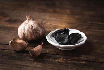 Black fermented garlic is a gourmet ingredient in cuisine for pasta, sauce and soups. rustic style,...