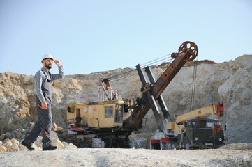 Worker in hardhat standing in stone quarry