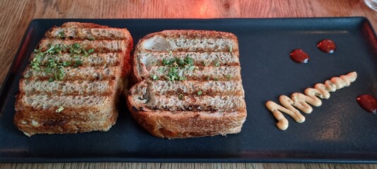 Fancy toast on black plate, homemade sour dough and cheese