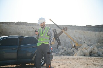 Extraction of stone. Male worker next to stone quarry. Engineer at construction site