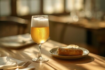 Shot pint of beer with white smooth foam and slices of bread on plate on wood table.