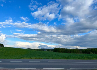 Beautiful landscape, blue sky and clouds. Green field. Spring.
