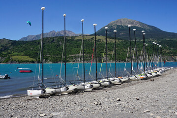 row of boats on the beach in serre ponçon lake , soutern alps, france