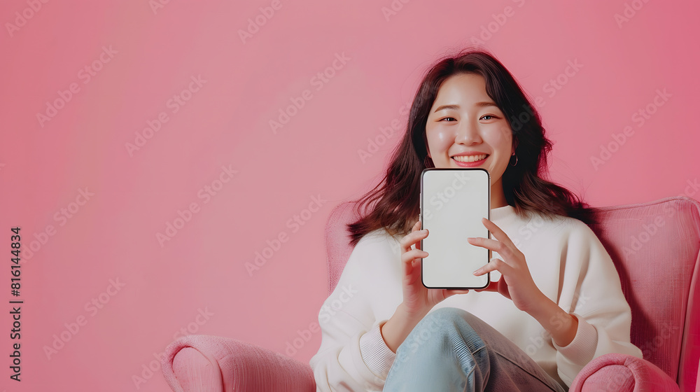 Aufkleber portrait of happy asian woman showing smartphone with white blank screen in hand sitting in armchair