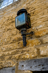 Old medieval lantern on a stone house wall. Old lantern hanging on the wall