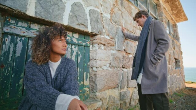 Frustrated pair feeling sad at chateau near ocean. Models posing abandoned place