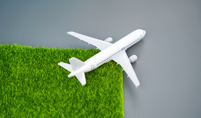 A passenger plane leaves green grass in its wake. Concept of environmental friendliness and clean...