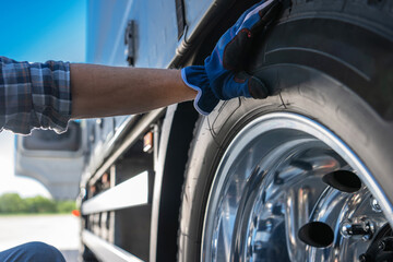 Trucker Examining Semi Truck Tire