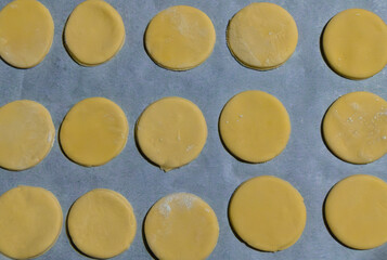 many cookies cut out in the shape of a circle with some flour and placed to make them on baking...