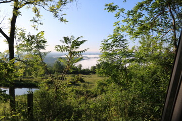 Mountain pond overlooking river fog with foliage
