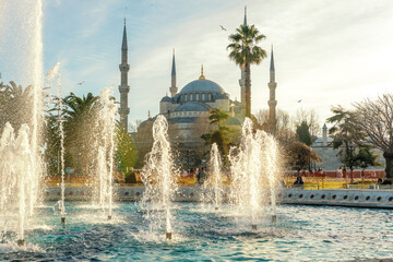 The Blue Mosque or Sultanahmet Mosque with fountains against the sunset. Istanbul, Turkey.