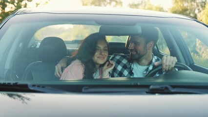 Happy man hugging his girlfriend while sitting in the car. Slow motion