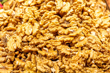 Heap of fresh raw brown crispy walnuts arranged on surface.