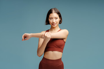 Smiling sporty woman wearing sportswear stretching, training, doing exercises isolated