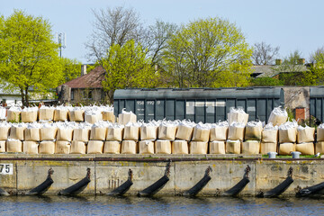 Bales of mineral fertilizers stacked on the bank of the harbor channel before loading onto a ship