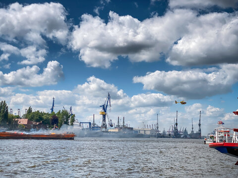 Rettungsaktion auf der Elbe: Seenotkreuzer und Hubschrauber im Einsatz vor dem Hintergrund des Hamburger Hafens
