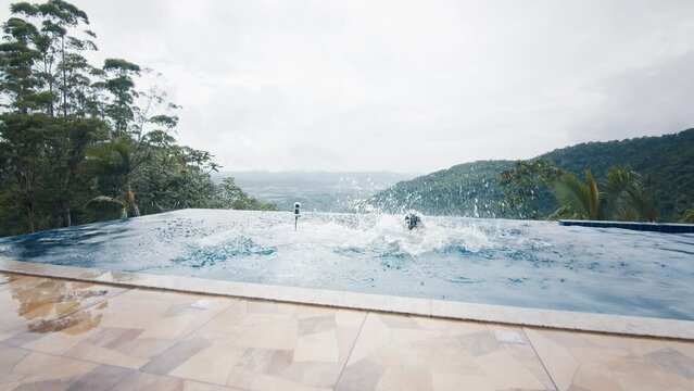 Couple runs with camera and jumps into the private pool. Influencers film a video with selfie stick