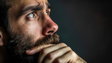 A man in deep contemplation questioning the purpose of life with hand on chin and beard