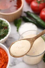 Spoon with fresh marinade over table, closeup