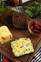 Tasty butter with green onion, chili peppers, rye bread and dill on table