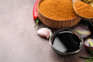 Soy sauce and different fresh ingredients for marinade on brown table, closeup. Space for text