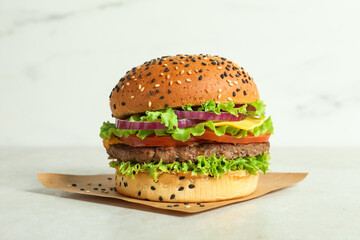 Burger with delicious patty on light table