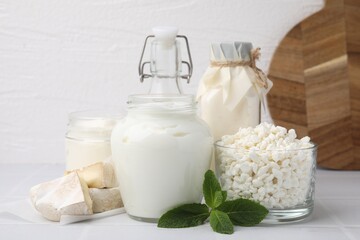 Different dairy products and mint on white table