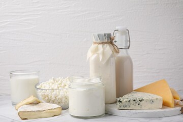 Different fresh dairy products on white marble table