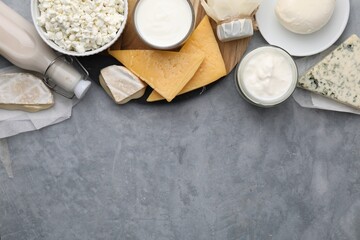 Different fresh dairy products on grey table, top view. Space for text