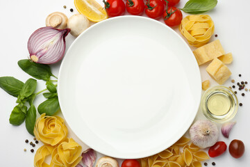 Plate surrounded by different types of pasta, products and peppercorns on white background, flat...