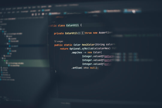 Close up of computer code under magnifying glass on computer screen