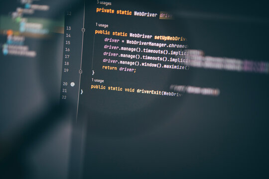 Program code on computer display under magnifying glass