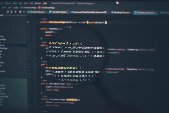Close up of computer code under magnifying glass on computer screen.