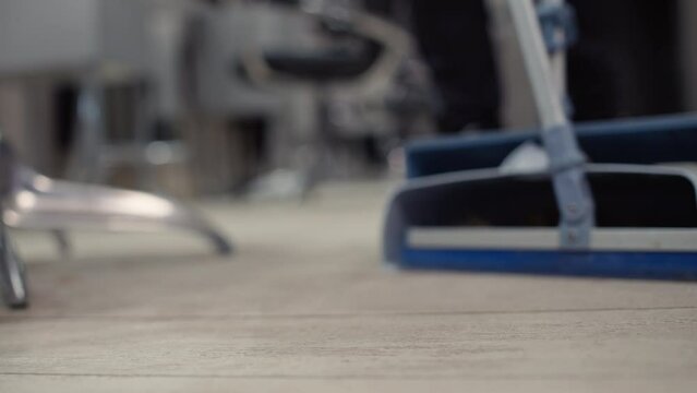 Close-up of a hairdresser sweeps hair in a barbershop after a haircut. Cleaning up after work. High quality 4k footage