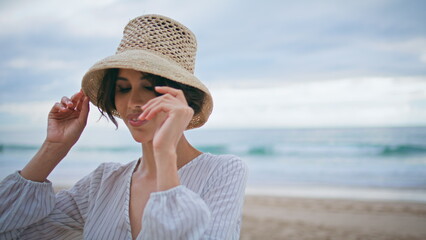 Beautiful girl rest seashore on cloudy day portrait. Smiling attractive tourist 