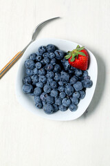 White bowl with fresh blueberries seen from above