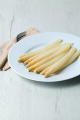 White plate with delicious white asparagus in closeup