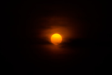 Glowing orange light shines against dark cloudy sky