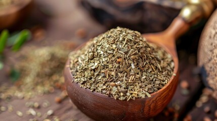 Wooden spoon filled with yerba mate, set against a background of fresh herbs.

