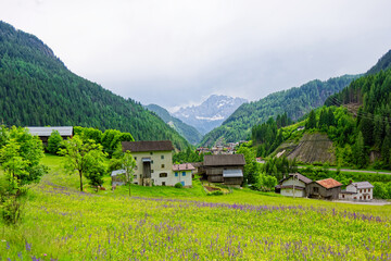 Fototapeta na wymiar Small rural village nestled in the Dolomite Mountains Italy.Green morning scene of countryside in Swiss Alps, Bernese italian in the canton of Bern, Switzerland, Europe. Alpine mountain pasture