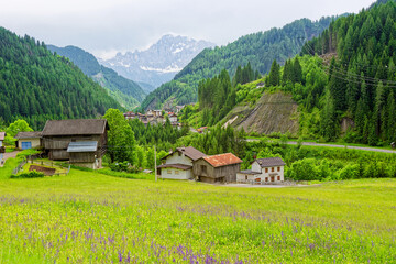 Fototapeta premium Small rural village nestled in the Dolomite Mountains Italy.Green morning scene of countryside in Swiss Alps, Bernese italian in the canton of Bern, Switzerland, Europe. Alpine mountain pasture