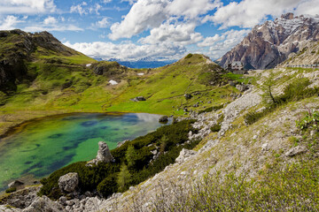 Alpine scenes of the Dolomite mountains Italy. With lush green pastures and snow topped mountain vistas. Mountain lake Laghi dei Piani near Tre Cime in Dolomites. Panorama of beautiful mountains.