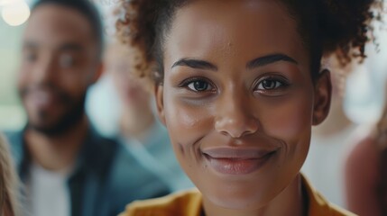 Close-up portrait of a young woman with a friendly smile, colleagues in blurred background - Powered by Adobe