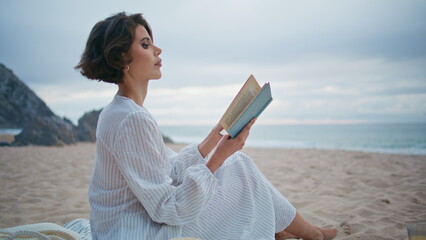 Outdoor woman enjoy book at cloudy seashore closeup. Romantic lady rest beach