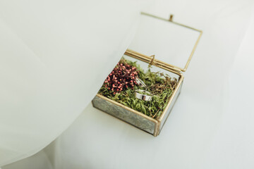Wedding rings in a beautiful handmade glass box with flowers