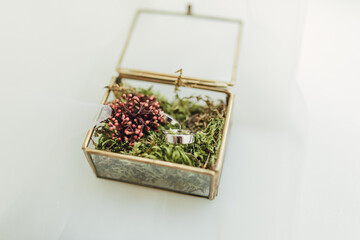 Wedding rings in a beautiful handmade glass box with flowers