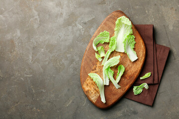 Pieces of fresh Chinese cabbage on gray textured table, top view. Space for text