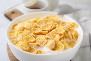 Breakfast cereal. Tasty corn flakes with milk in bowl on table, closeup