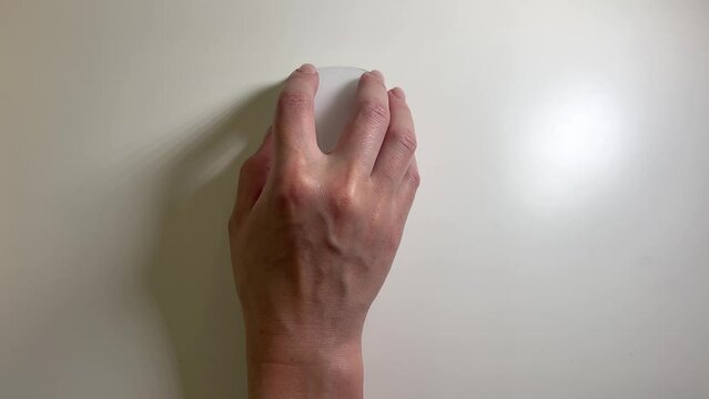 top view hand using white mouse button on white office desk. 