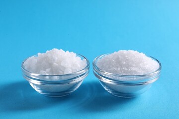 Natural salt and bowls on light blue background